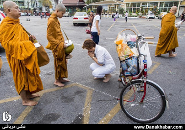 ادای احترام یک زن تایلندی به راهبان بودایی در روز 