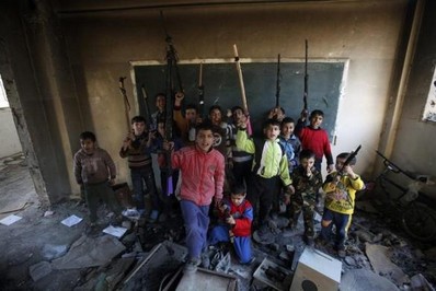 عکس یادگاری کودکان دانش آموز سوری در مدرسه ای تخریب شده در شهر دیر الزور با تفنگ های اسباب بازی
