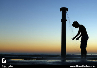 دوش گرفتن پسری هنگام غروب آفتاب در ساحل دریا؛ کاردیف، کالیفرنیا. (رویترز)
