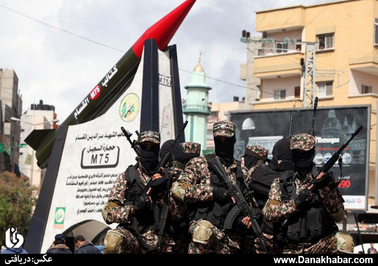 گردان های القصام وابسته به حماس در حال نمایش یک راکت ساخت این گروه در میدانی در غزه